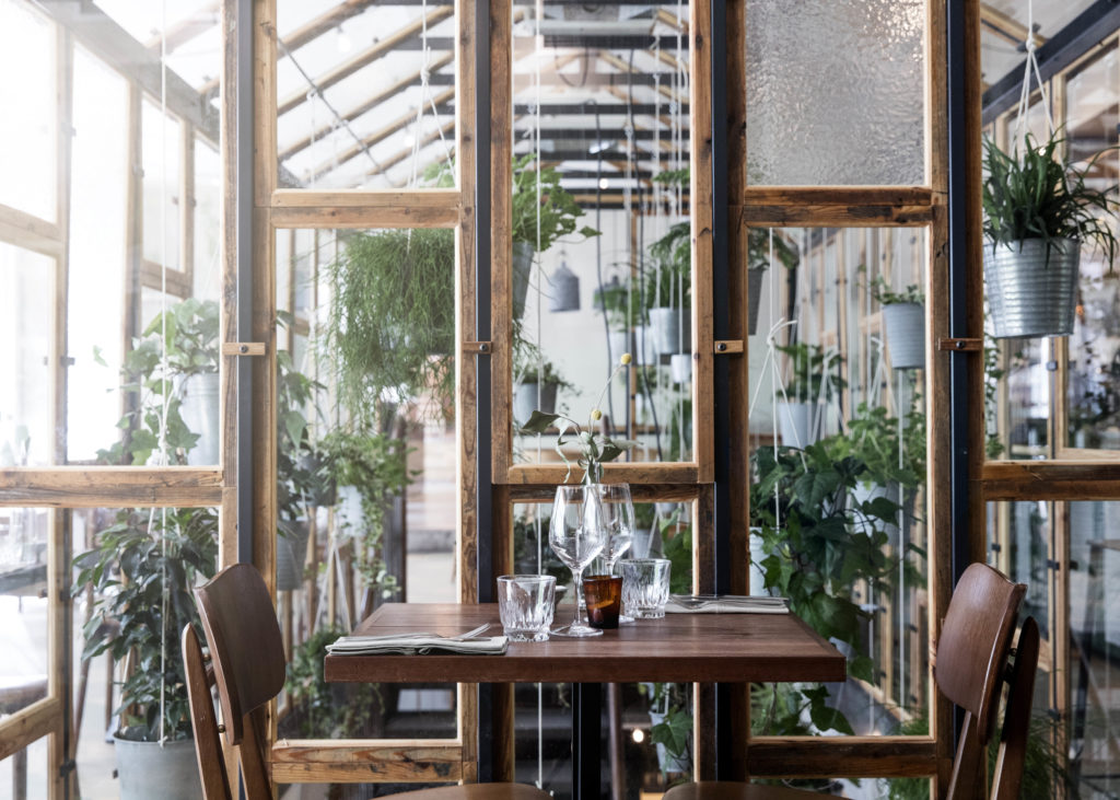 Drivhuset giver et organisk udtryd og forbinder restaurantens to etager. Alle mahognilister er lavet ud af den gamle tribune på Lyngby Stadion.